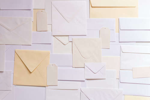 Many envelopes in hues of white, pale yellow and blue